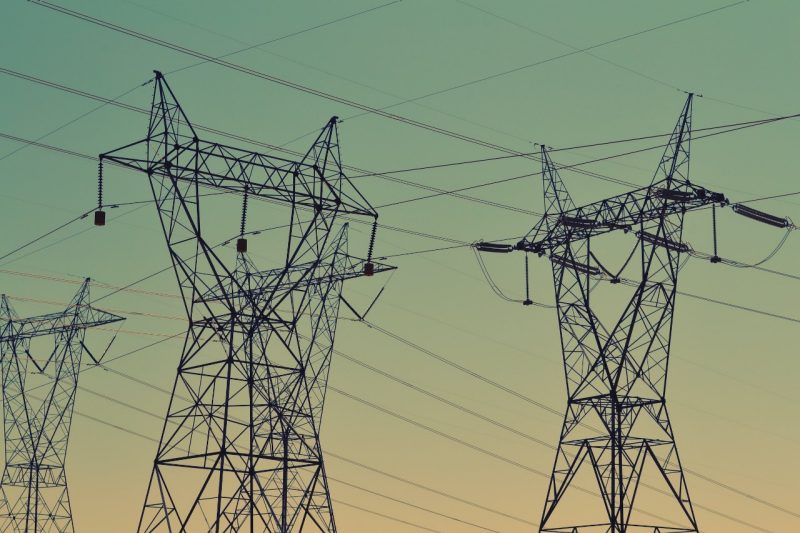 Power lines against a blue-green-yellow sky.