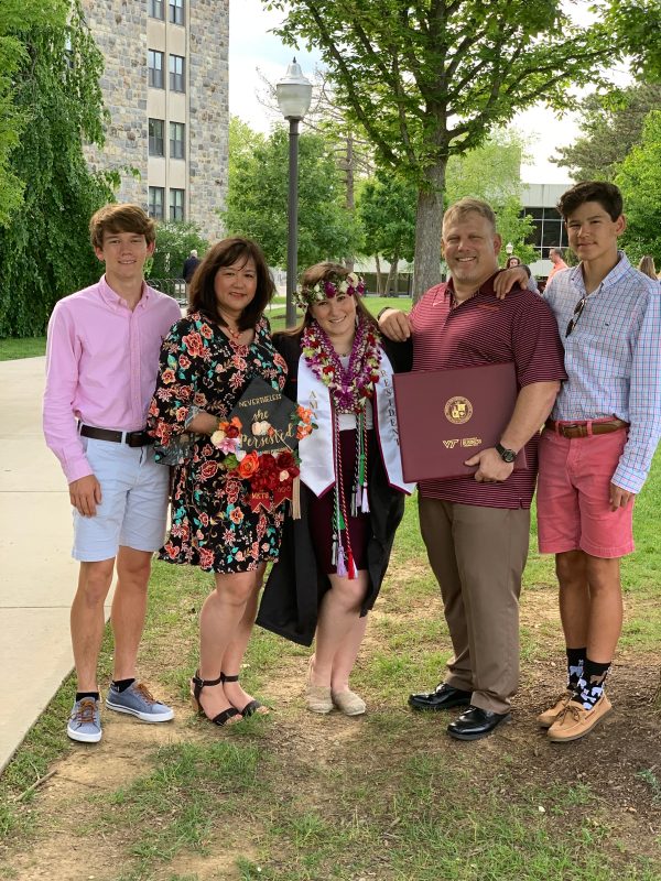 Sarah Preston posing with family at graduation. 